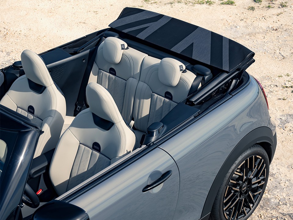 Angled overhead shot of the new MINI Cooper Convertible with an open top, offering a view of the sportive seating.